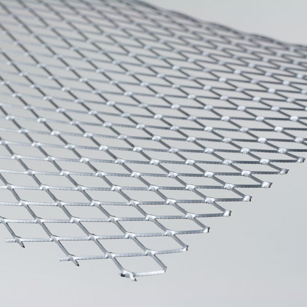 Close-up of expanded metal mesh with diamond pattern in silver color against white background